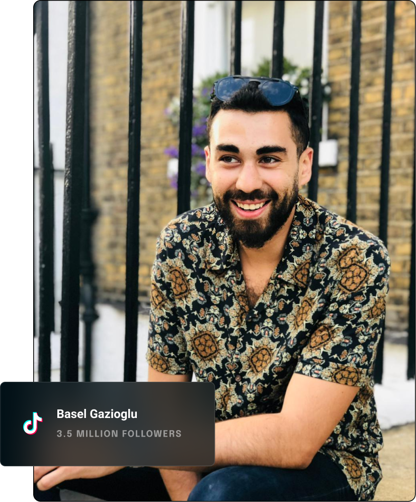 Youtube influencer looking away from the camera and smiling while sitting on a curb.